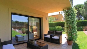 A patio with a glass door leading to a garden, outdoor furniture, and a potted plant. - Club Villamar - Fully detaches 8-persons vila, ideal for families at only 4 kilometers away from ... (Mont Ras)