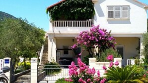 Una casa a due piani con un balcone, un cancello e il numero 24.