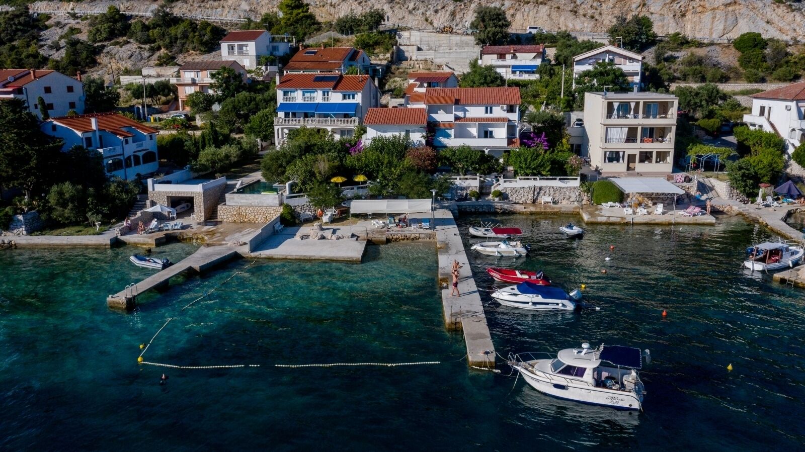 Un village côtier avec des maisons, un quai et des bateaux.