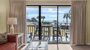 Une chambre avec vue sur la plage, comprenant un canapé, une table et une lampe.
