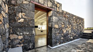 Un edificio de piedra con una puerta de madera que da a un espacio interior.