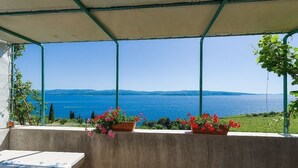 A balcony with a view of the sea, potted plants, and a table. - Apartment in Murvica with Seaview, Terrace, Air condition, WIFI (146-4) (Murvica)
