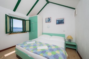 A bedroom with a bed, a window, a nightstand, and two framed pictures on the wall. - Apartment in Murvica with Seaview, Terrace, Air condition, WIFI (146-4) (Murvica)