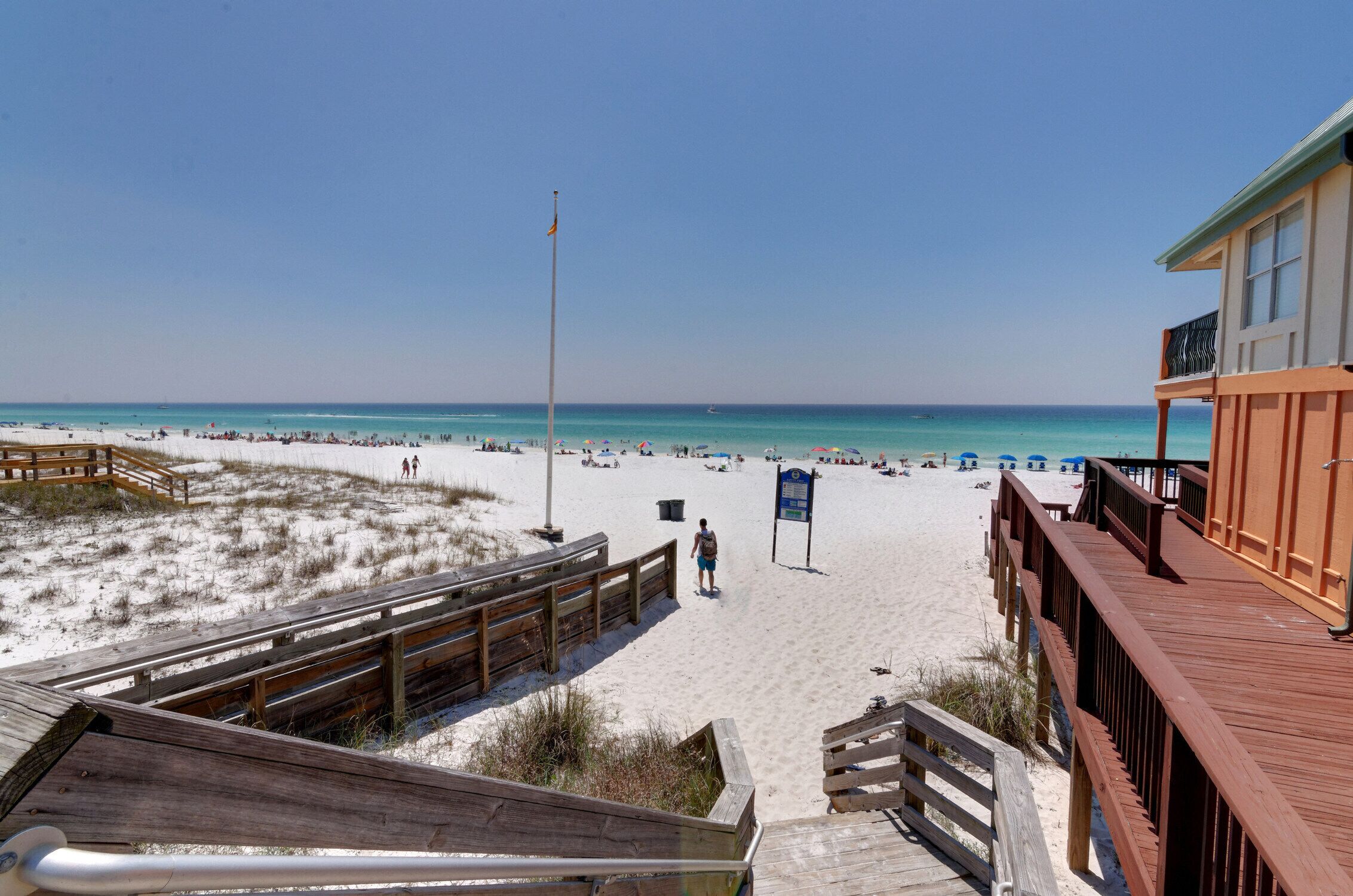 A beach with wooden walkways and a lifeguard tower.