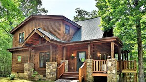A log cabin with a stone foundation, a wooden porch, and a stone staircase leading to the entrance. - Shady Lady Cabin in The Smokies with Beautiful Views, Just 5 miles from Town (Sevierville)