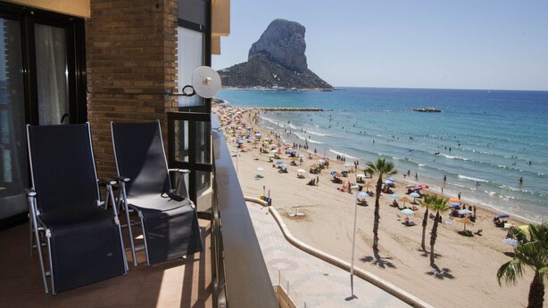 A balcony with two chairs and a satellite dish, overlooking a beach with umbrellas and palm trees. - A59 CALPEMAR A 5º 18 (Calpe)
