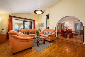 Un salon comprenant deux canapés, une table basse et un coin repas avec une table et des chaises.