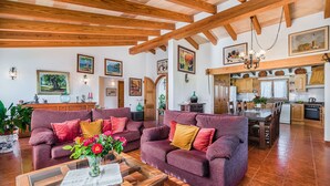 A spacious living room with two sofas, a coffee table, and a dining area with a kitchen in the background. - BLANCO  Ref. VP08 (Pollensa / Pollença)