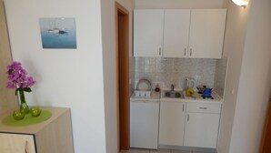A compact kitchen with white cabinets, a tiled backsplash, and a small countertop. - Studio apartment in Duće with Seaview, Balcony, Air condition, WIFI (4173-8) (Duce)