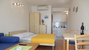 A compact room with a bed, a small table, a chair, a kitchenette, and a bathroom. - Studio apartment in Duće with Seaview, Balcony, Air condition, WIFI (4173-8) (Duce)