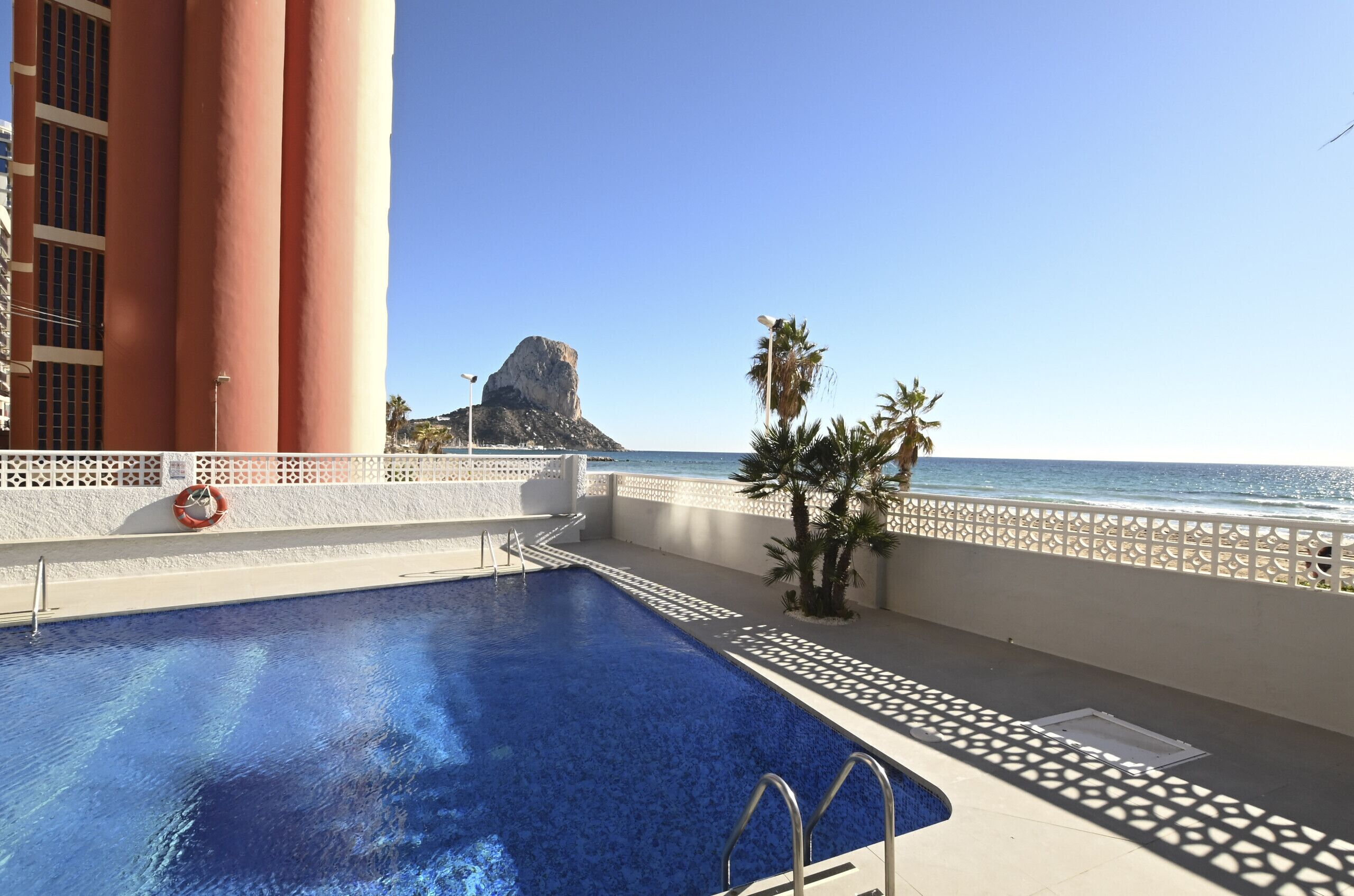 Una piscina amb vista a l'oceà i una formació rocosa al fons.
