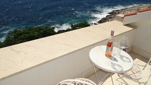 A balcony with a table and chairs overlooking a coastal view. - Apartment in Hvar town with Seaview, Loggia, Air condition, WIFI (199-3) (Hvar)