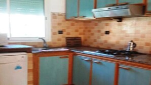 A kitchen with teal cabinets, a stove, and a dishwasher. - Nice Duplex in Sidi Bouzid 4381 (Sidi Bouzid)