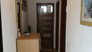 A narrow hallway with a wooden counter, a sink, and a mirror. There is a framed picture on the wall and a door leading to another room. - Apartment in Stanići with Seaview, Balcony, Air condition, WIFI (634-3) (Stanici)