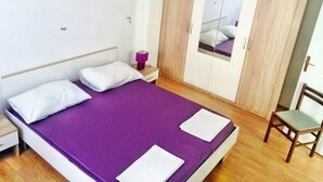 A bedroom with a bed, a wardrobe, a nightstand, and a chair. - Apartment in Vodice with Terrace, Air condition, WIFI (4441-3) (Vodice)