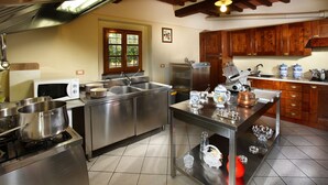 A modern kitchen with stainless steel appliances, a central island with barware, and wooden cabinets. - Villa in Montecatini with 11 bedrooms sleeps 22 (Montecatini)