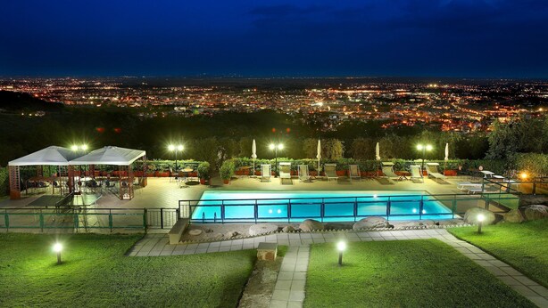 A nighttime view of a pool area with a cityscape in the background. - Villa in Montecatini with 11 bedrooms sleeps 22 (Montecatini)