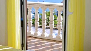 Une pièce dotée d’un balcon avec une balustrade blanche et des rideaux jaunes.