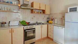 Une cuisine équipée d’une cuisinière, d’un four, d’un évier et de placards.