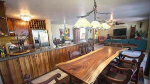 Une cuisine spacieuse dotée d’un grand îlot central en bois, de meubles de rangement en bois et d’un réfrigérateur encastré.