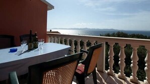 A balcony with a table set for dining, overlooking a scenic view of the sea and mountains. - Apartment in Kožino with Seaview, Balcony, Air condition, WIFI (4262-1) (Kožino)
