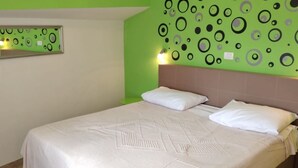 A bedroom with a bed, two pillows, a mirror, and a wall with circular patterns. - Apartment in Medulin with Seaview, Balcony, Air condition, WIFI (112-5) (Medulin)