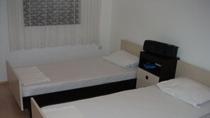 A room with two single beds, a nightstand with a radio, and a window with sheer curtains. - Apartment in Lokva Rogoznica with Seaview, Balcony, Air condition, WIFI (88-1) (Lokva Rogoznica)