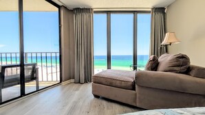 A room with a large window overlooking the ocean, a sofa, and a lamp. - Tower III, 7th floor Beachfront Master (Panama City Beach)