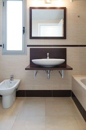 A modern bathroom with a pedestal sink, a bidet, and a bathtub. - Amazing round floor apartment for families - UHC SALOU VILLA 302 (Salou)