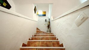 Una scala con pareti bianche e un lampadario sopra.