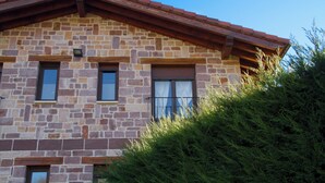 Un bâtiment en pierre avec un toit rouge et de nombreuses fenêtres.