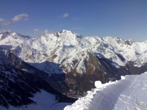 A mountain range with snow-covered peaks and a clear sky.