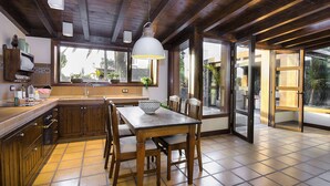 Una cocina con armarios de madera, una mesa de comedor y sillas.