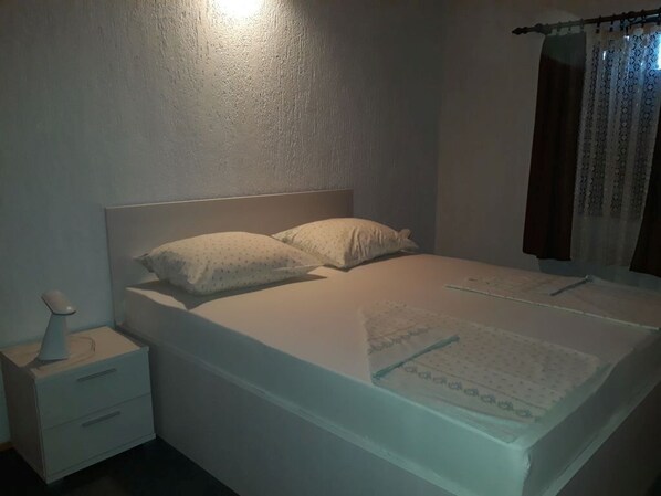 A bedroom with a single bed, a bedside table, and a nightstand.