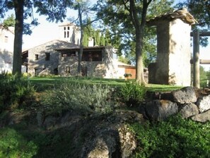 A stone building with a rustic appearance, surrounded by greenery and trees. - Cottage (full rental) Can Llorigó for 8 people (Olot)