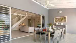Ein moderner Essbereich mit Glastrennwand, einer Treppe und Blick ins Freie.
