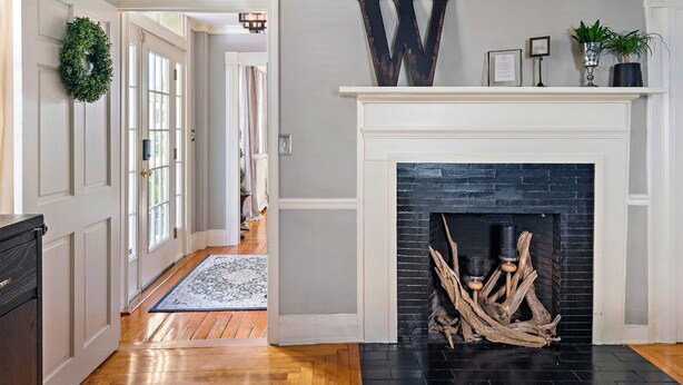 A hallway with a fireplace, a wreath on the door, and a wooden floor. - The Watson Boutique Bed & Breakfast (Thompson)