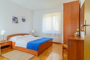 A bedroom with a wooden bed, a nightstand, a desk, and a chair. - Apartment in Okrug Gornji with Seaview, Terrace, Air condition, WIFI (5209-4) (Okrug Gornji)