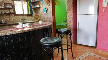 Een koelkast, een kookplaat, kookgerei, borden en bestek