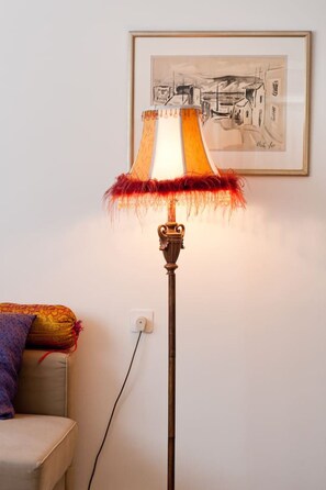 A floor lamp with a decorative shade and a framed artwork on the wall.