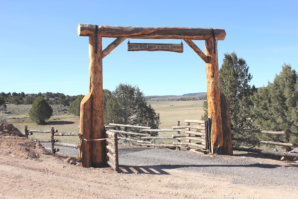A rustic wooden archway with a sign reading "Sevier River Ranch & Cattle Company."