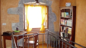 Una habitación con un escritorio de madera, una silla y una estantería.
