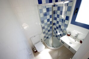 A modern bathroom with a glass shower enclosure, a toilet, and a sink with a mirror. - 92 - Apartamento Namasté (Tarifa)