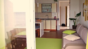 A compact living space with a kitchenette, a sofa with cushions, and a dining area. - Apartment in Poljana with Seaview, Terrace, Air condition, WIFI (3617-5) (Poljana)