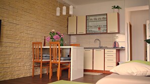 A compact kitchen with wooden cabinets, a dining area with a table and chairs, and a small countertop with a sink. - Apartment in Poljana with Seaview, Terrace, Air condition, WIFI (3617-5) (Poljana)