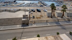 A coastal marina with boats, a clear sky, and a view of the sea. - 293 - Apartamento El Puerto (Tarifa)