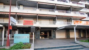 Un edificio a più piani con balconi, un cartello con la scritta 'Bell Tavern' e un cartello con la scritta 'Jatin Sp'.