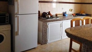 Une cuisine équipée d’un réfrigérateur, d’une cuisinière et de placards.