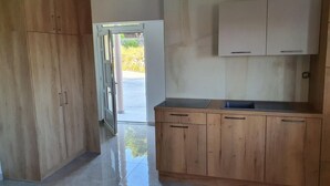 A modern kitchen with wooden cabinets, a countertop, and a view of the outdoors. - Apartment in Banjol with Seaview, Balcony, Air condition, WIFI (605-3) (Banjol)