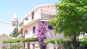 A two-story building with a balcony, a stone tower, and a car parked in front. - Apartment in Pakoštane with Seaview, Balcony, Air condition, WIFI (3539-2) (Pakoštane)